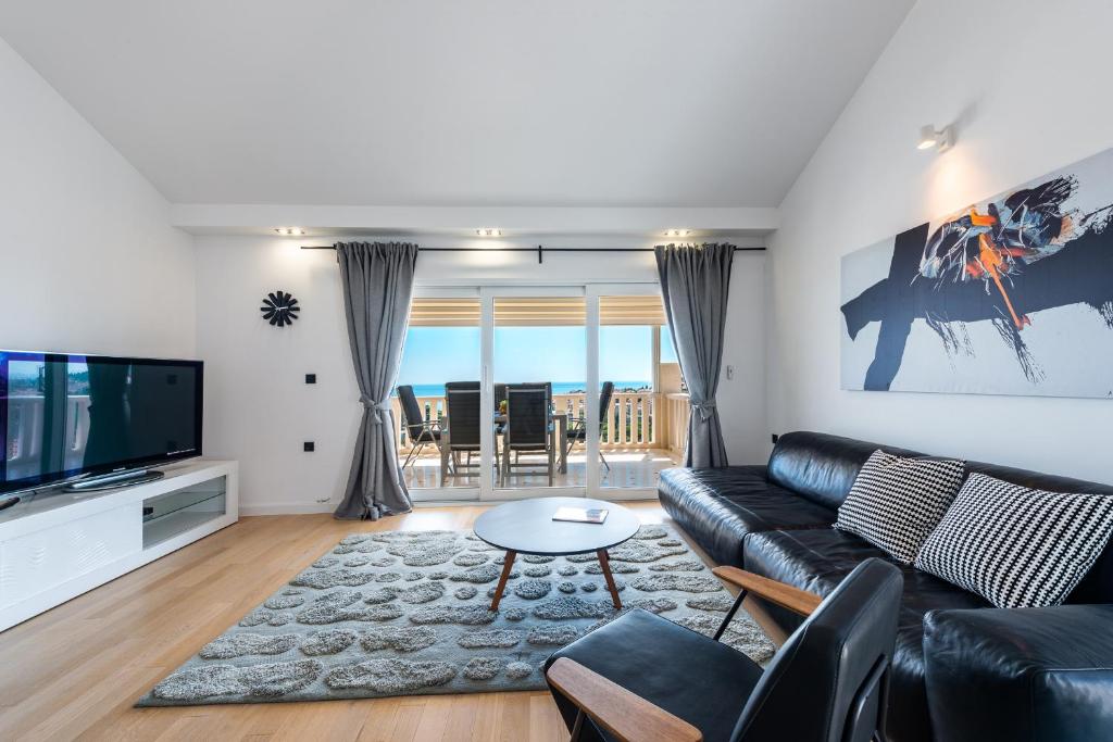 ein Wohnzimmer mit einem Sofa und einem TV in der Unterkunft Vista deluxe apartment in Dubrovnik