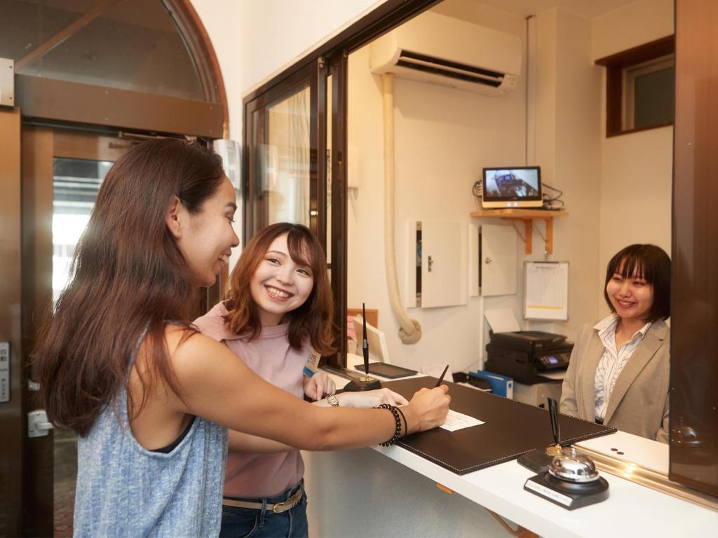 沖縄市にあるオキナワシティホテルの店のカウンターに立っている女性
