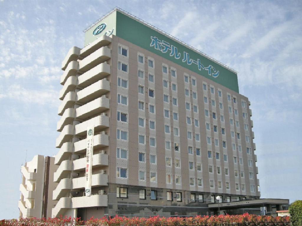 ein großes Gebäude mit einem Schild darüber in der Unterkunft Hotel Route-Inn Yatsushiro in Yatsushiro