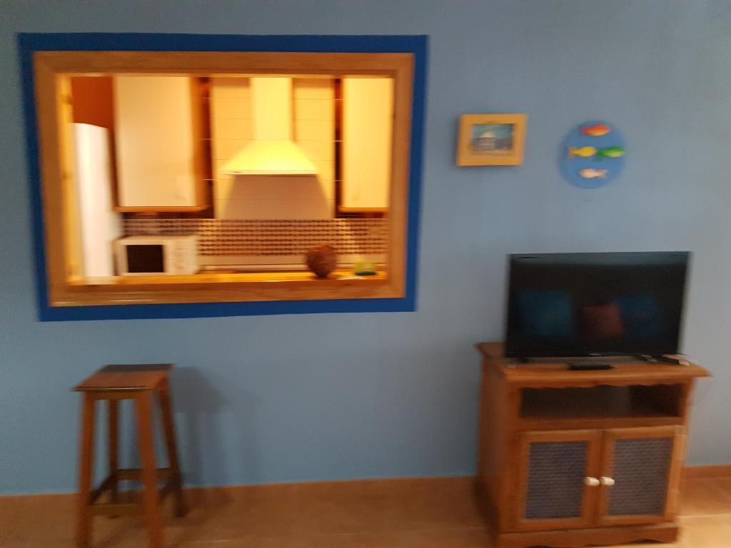a living room with a mirror and a tv at Apartamentos Atlanterra COSTA Y SOL in Zahara de los Atunes