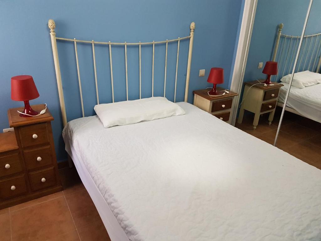 a bedroom with a bed and two night stands with lamps at Apartamentos Atlanterra COSTA Y SOL in Zahara de los Atunes