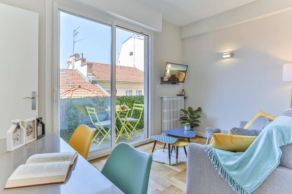 un salon avec une table et des chaises et une fenêtre dans l'établissement Maison Bianchi - 45 Berlioz, à Nice