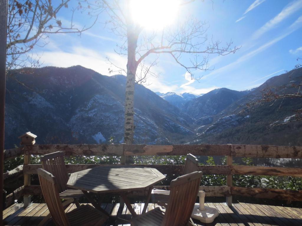 uma mesa e cadeiras num deque com vista para as montanhas em Le Chalet de Larcat em Larcat