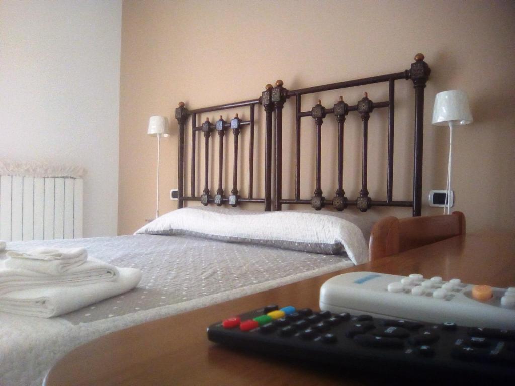um quarto com uma cama com um controlo remoto sobre uma mesa em Federicocasa em Alberobello