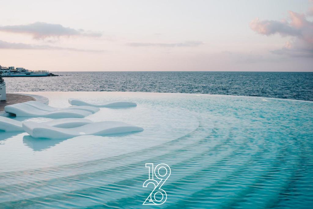 a infinity pool with the ocean in the background at 1926 Le Soleil Hotel & Spa in Sliema