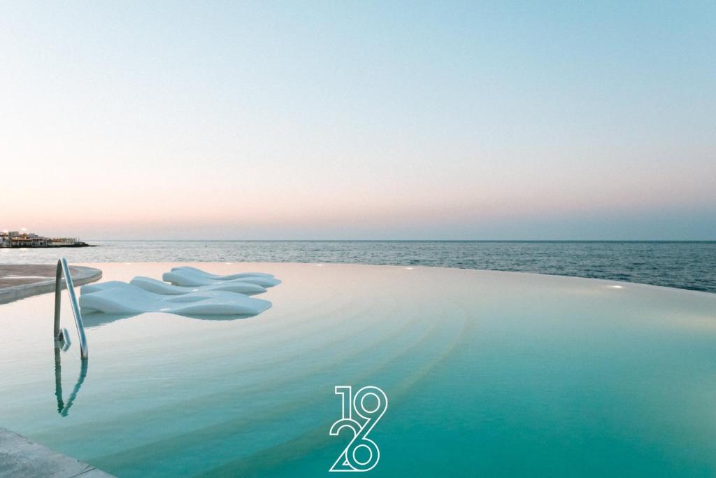 a infinity pool with the ocean in the background at 1926 Le Soleil Hotel & Spa in Sliema