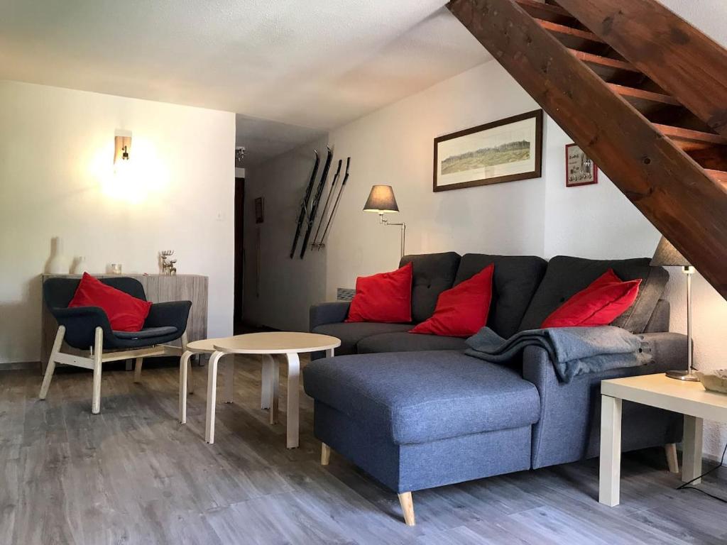 a living room with a blue couch and red pillows at Grand T3 en duplex pour 6 avec parking couvert in Cauterets