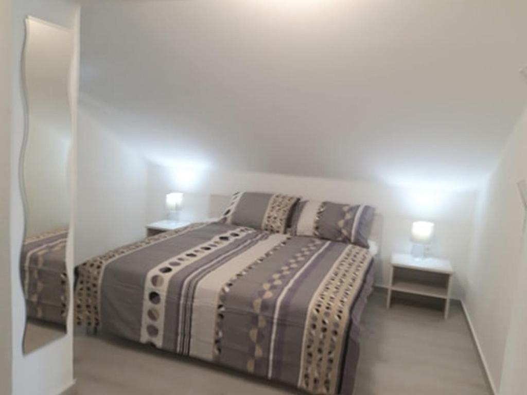 1 dormitorio pequeño con 1 cama y 2 mesitas de noche en Apartments Marino, en Senj