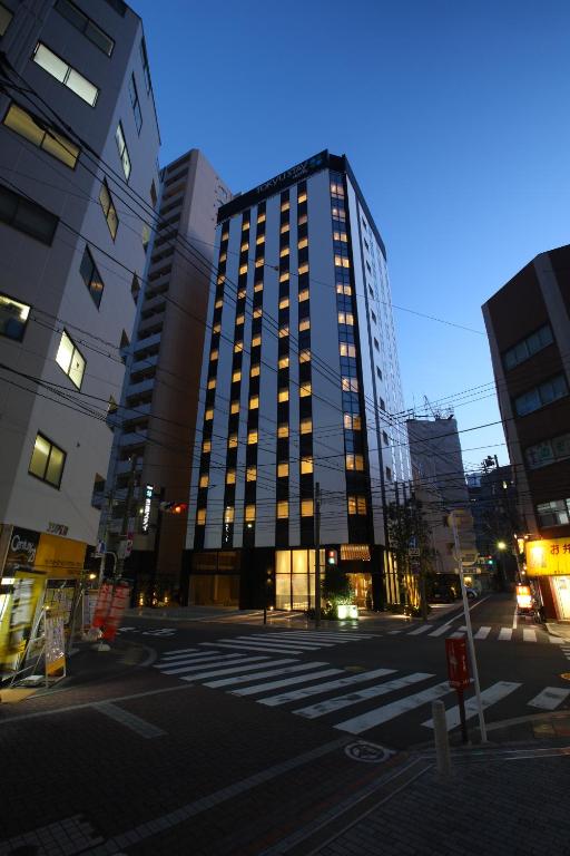 a tall building in the middle of a city at Tokyu Stay Kamata - Tokyo Haneda in Tokyo