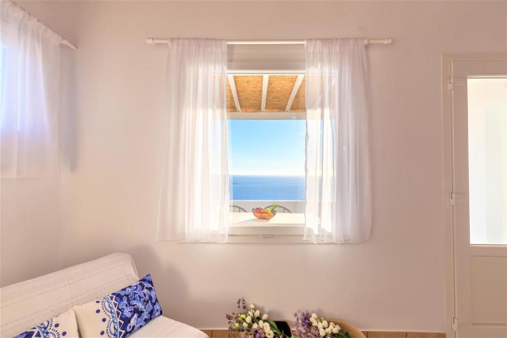 a living room with a window with a view of the ocean at Sugar Blue in Mýkonos City