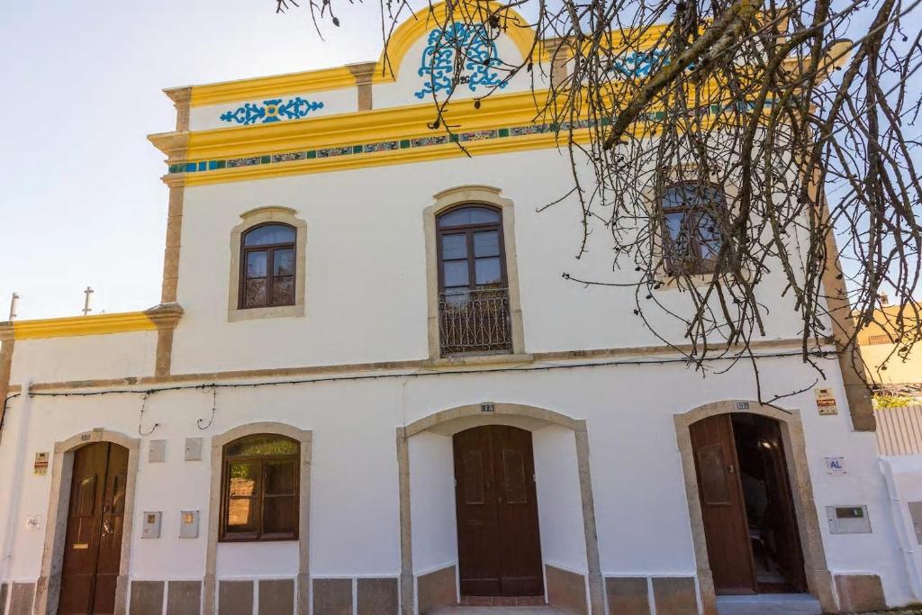 duży biały budynek z żółtą wieżyczką w obiekcie Solar da Rosa & Solar da Tirosa w mieście Boliqueime