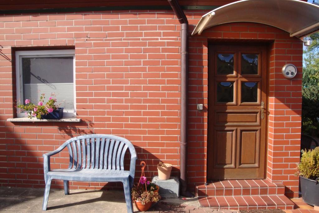 a blue chair sitting in front of a brick house at Ferienquartier Müller T6 in Trassenheide