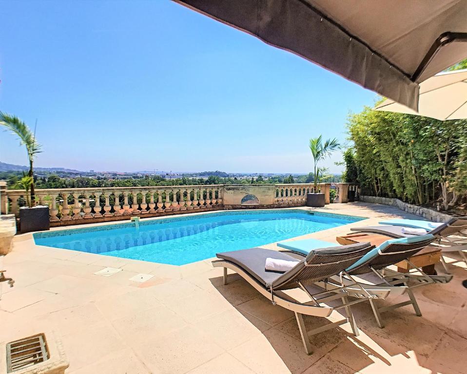 芒德留拉納普勒的住宿－3 Bedrooms Villa near Cannes - Pool & Jacuzzi - Sea View，游泳池旁设有2把躺椅