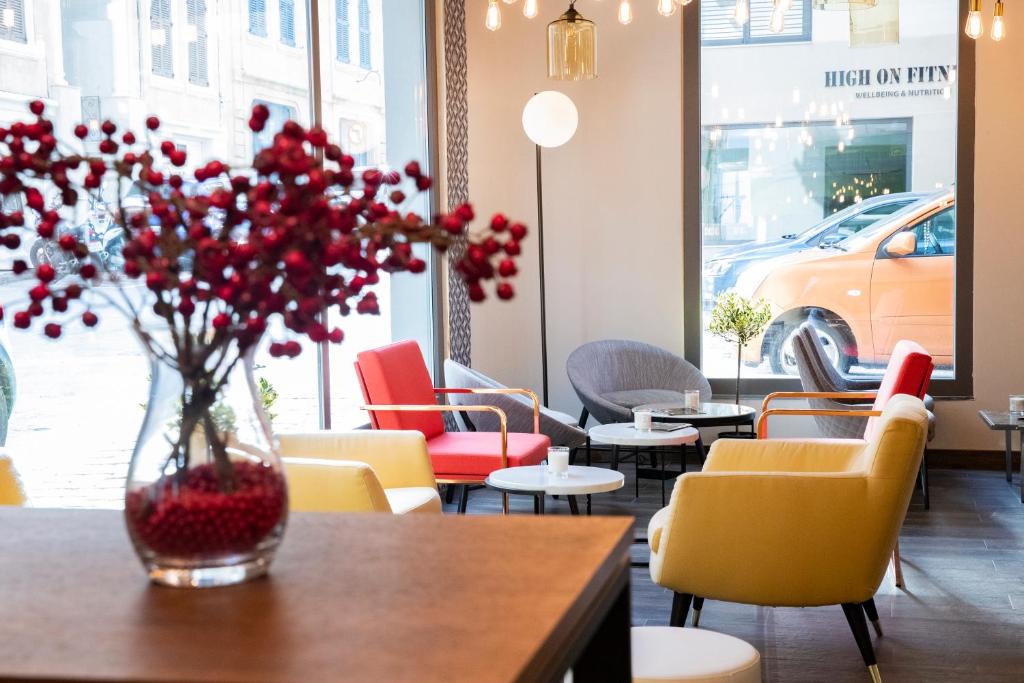 a vase with red flowers sitting on a table in a restaurant at 1926 Le Soleil Hotel & Spa in Sliema