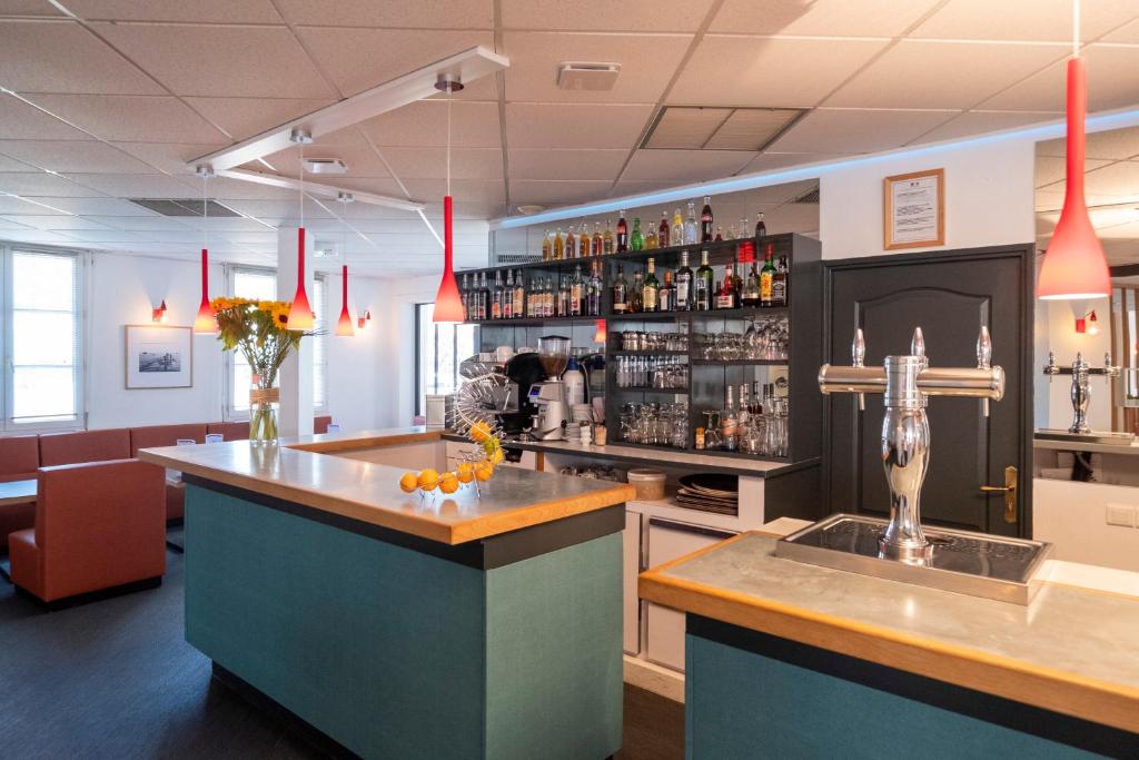 a bar in a restaurant with a counter and a bar sidx sidx sidx at Thalacap Île de Ré - Thalasso & Spa in Ars-en-Ré