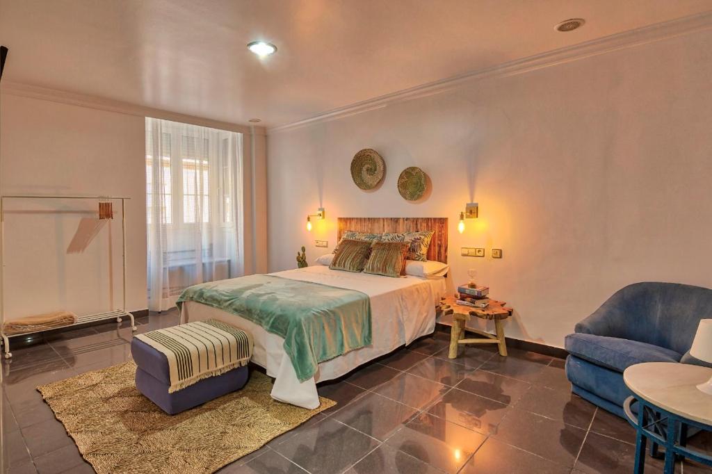 a bedroom with a bed and a couch and a chair at ROOMQUEO-Only Adults in Barbate