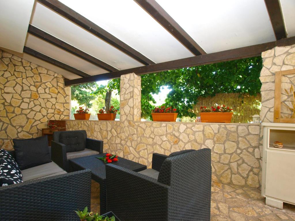 patio z krzesłami i kamienną ścianą w obiekcie Apartment Alenka 1930 w mieście Banjole