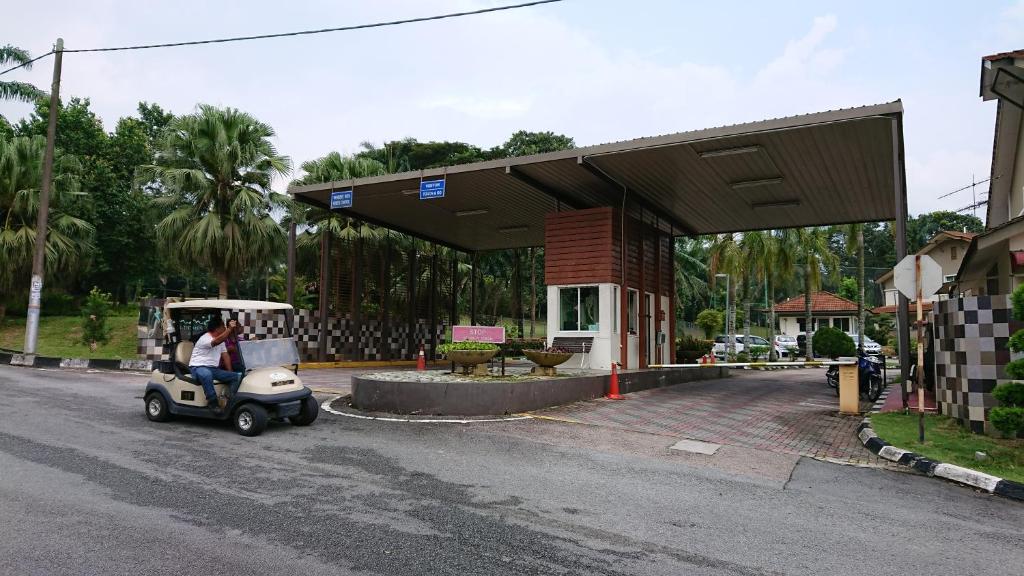 a golf cart parked in front of a gas station at Homestay Bandar Putra Kulai in Kulai