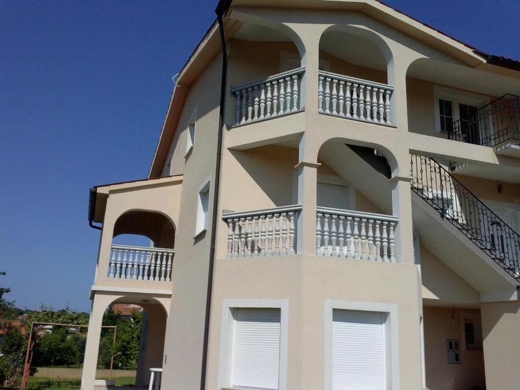 een wit gebouw met balkons aan de zijkant bij Apartmani Slavko in Fažana