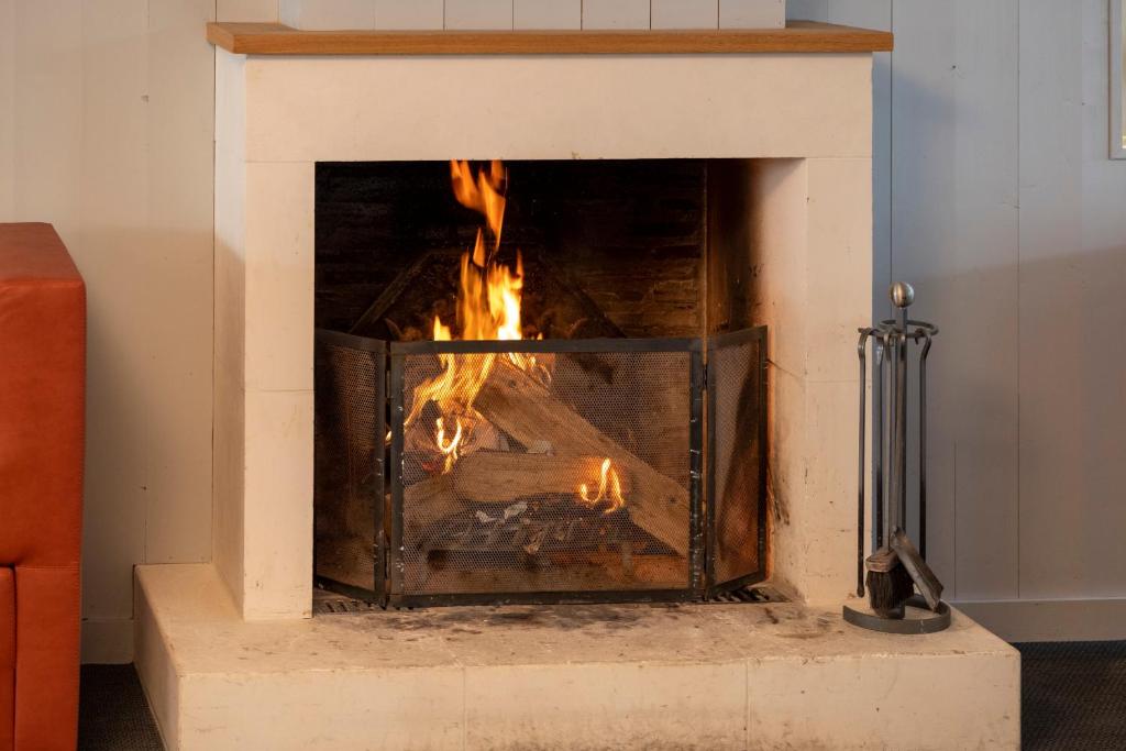 a fireplace with a fire in it at Thalacap Île de Ré - Thalasso & Spa in Ars-en-Ré