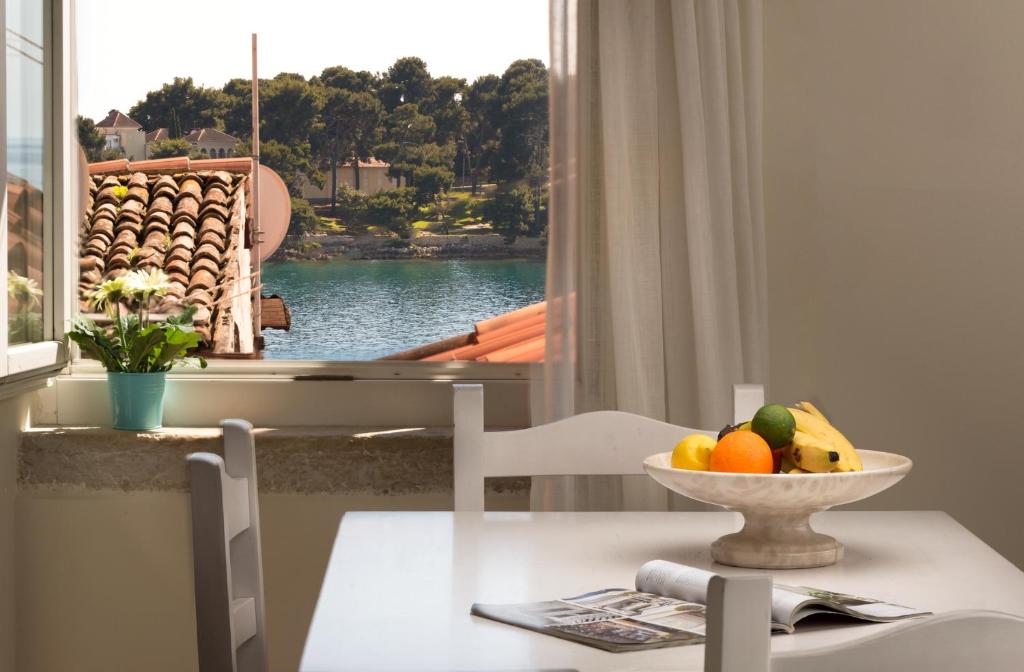 una mesa con un bol de fruta y una ventana en Angelo d'Oro Apartments Trevisol, en Rovinj