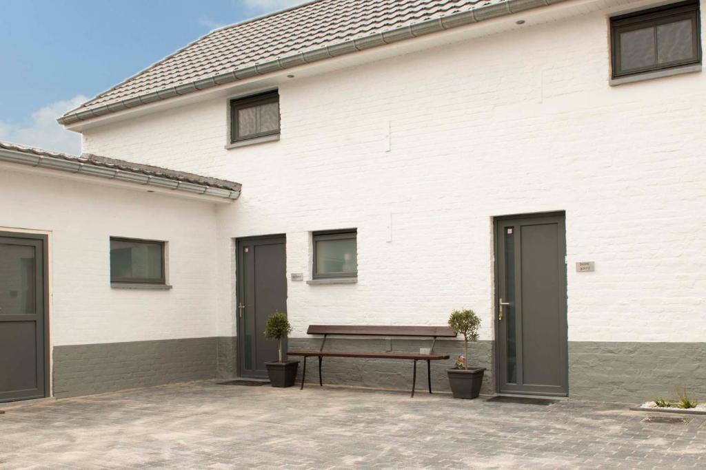 a white building with a bench in front of it at Het Landsleven in Gingelom