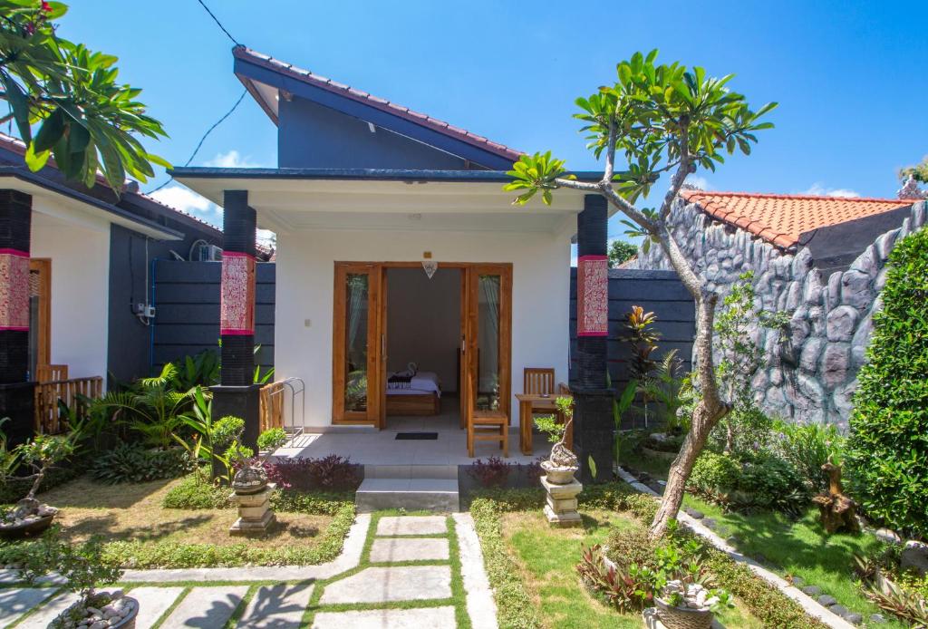 a villa with a garden and a house at The Box House in Nusa Penida