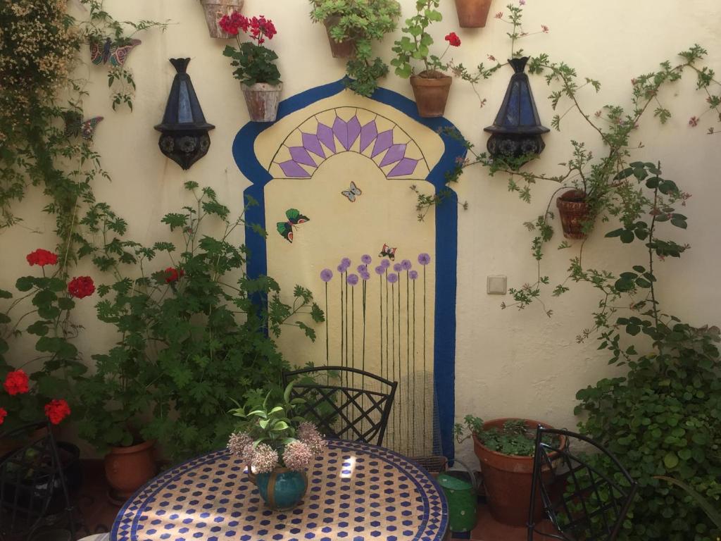 una mesa en un jardín con una puerta y plantas en Baraka Pensión en Ronda