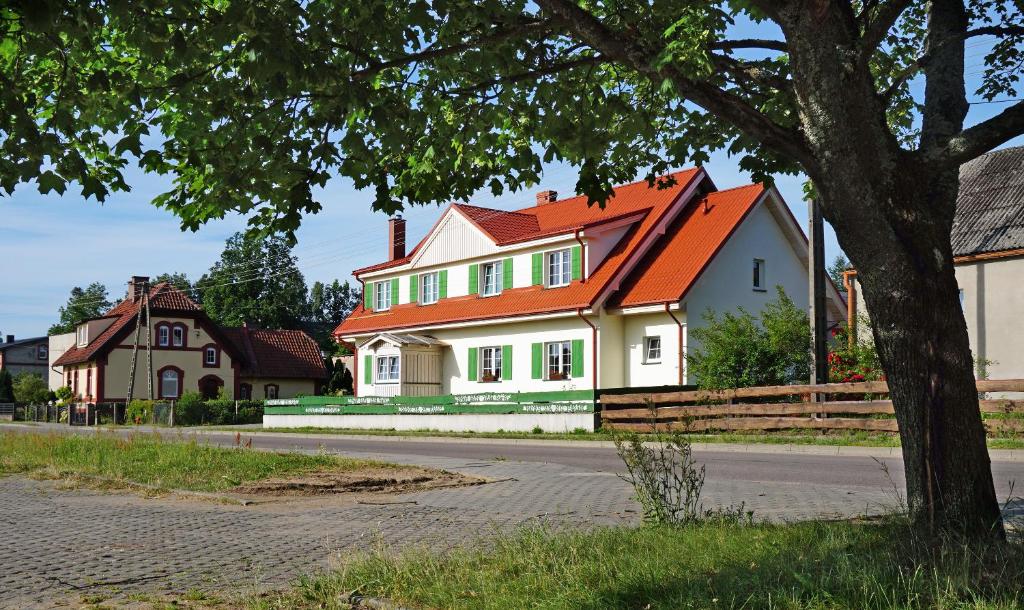duży biały dom z pomarańczowym dachem w obiekcie Agroturystyka Zielony Kot w mieście Lipusz