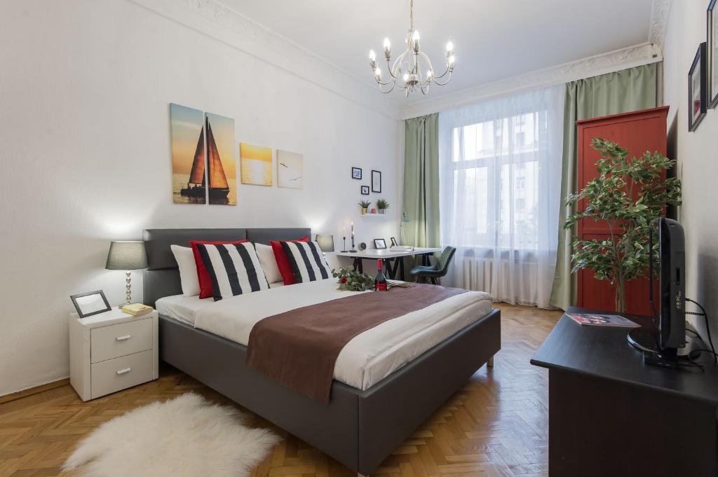 a bedroom with a bed and a desk and a television at GMApartments Tverskaya street in Moscow