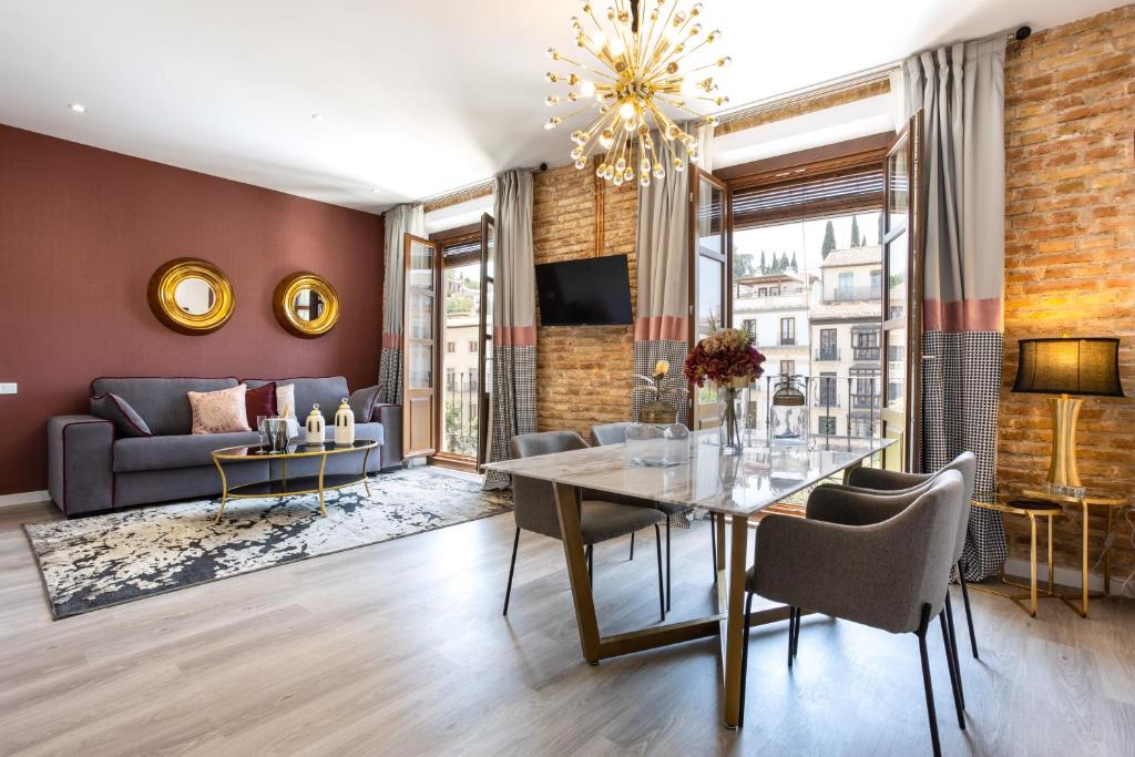 a living room with a dining table and a couch at BiBo Suites Plaza Nueva in Granada