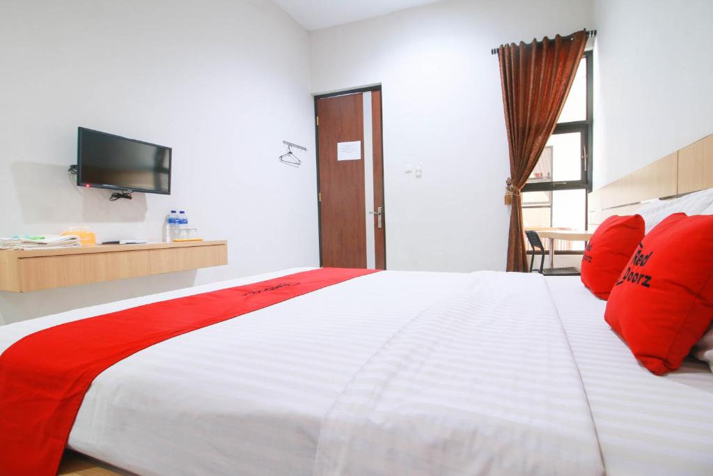 Postel nebo postele na pokoji v ubytování RedDoorz Syariah near Universitas Jenderal Soedirman