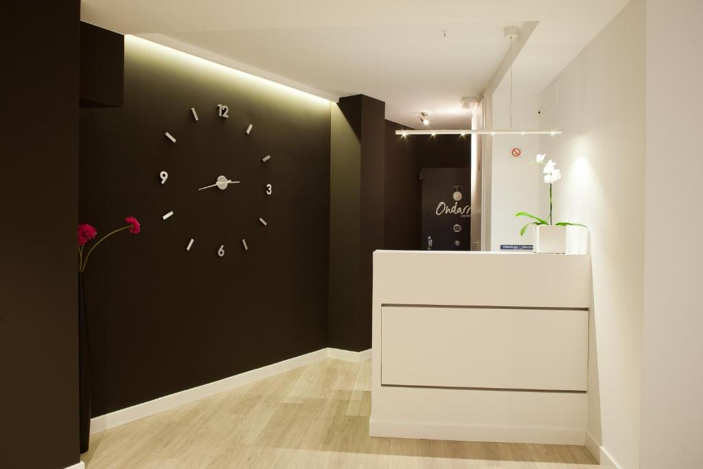 Una habitación con una pared negra con un reloj. en Pension Ondarra Autocheck-In, en San Sebastián