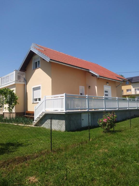 a house with a balcony and a yard at Rooms Josip in Korenica
