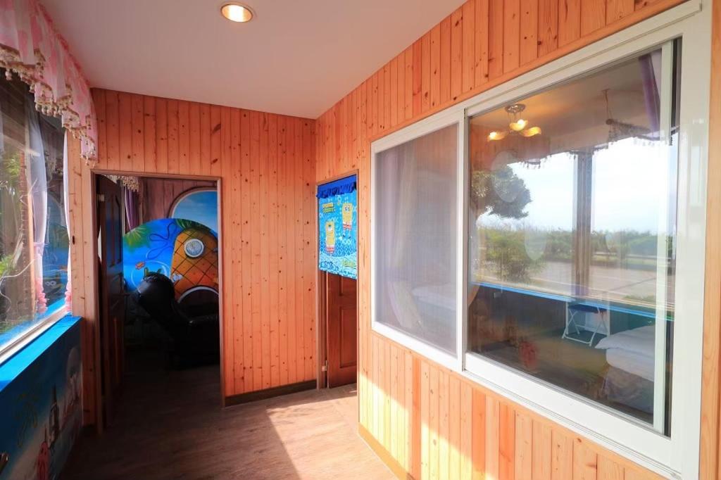 a room with wood paneled walls and a window at Sunny Ocean B&amp;B in Yanliau