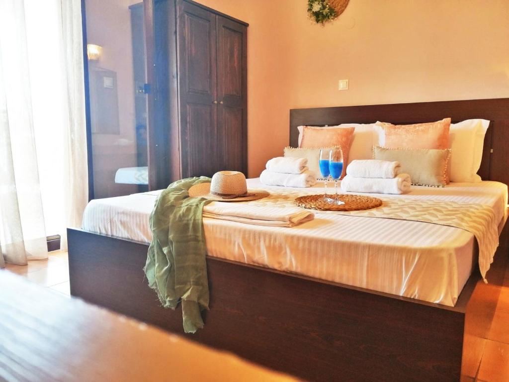 ein Bett mit einem Hut und einem Weinglas darauf in der Unterkunft Pension Anastasia in Amolianí