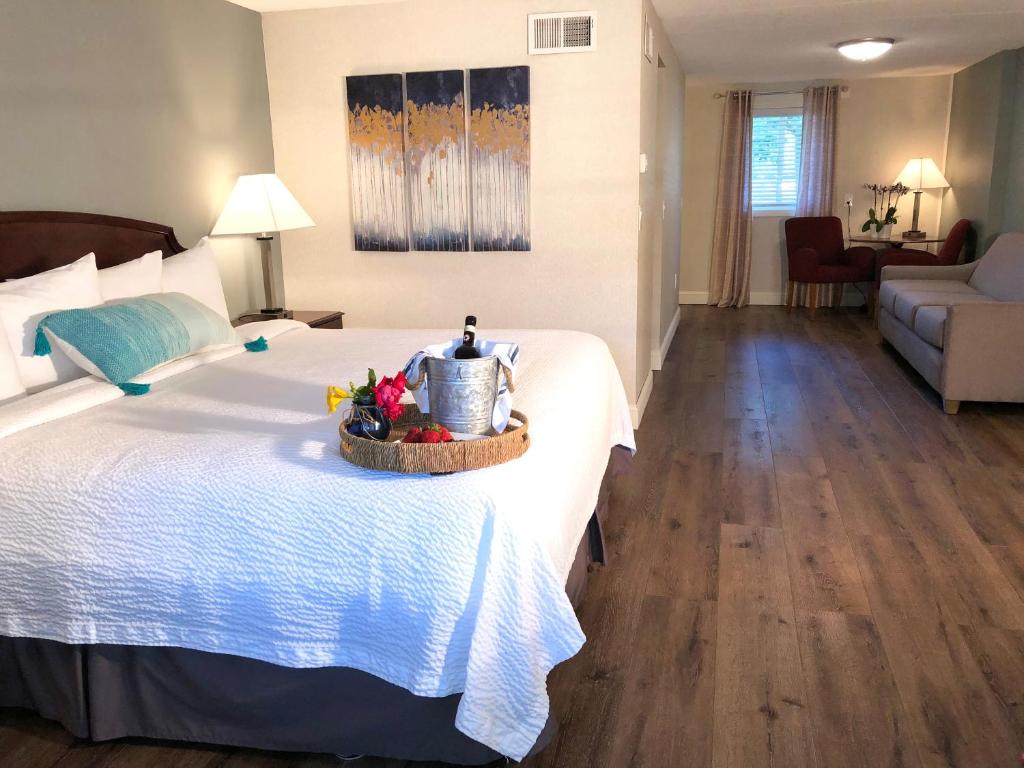 a hotel room with a bed with a basket of flowers on it at Hyannis Inn in Hyannis