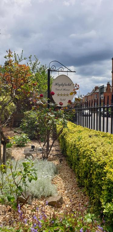 un panneau indiquant un jardin avec des fleurs et une clôture dans l'établissement Highfield Guest House, à Édimbourg