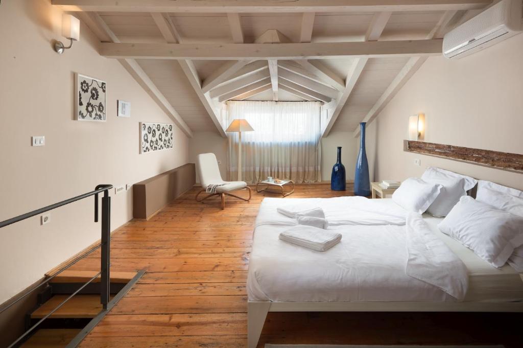 - une chambre mansardée avec un grand lit blanc dans l'établissement Angelo d'Oro Holiday Home Silva, à Rovinj