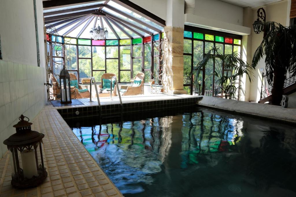 a swimming pool in a house with stained glass windows at Chambres d'Hôtes Justin de Provence in Orange