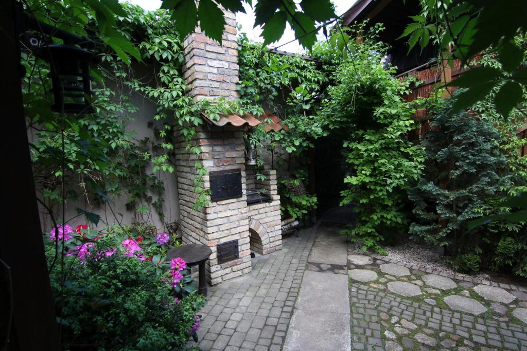 un jardin avec un bâtiment en brique orné de plantes et de fleurs dans l'établissement Apartamenty pod Wiciokrzewem, à Supraśl
