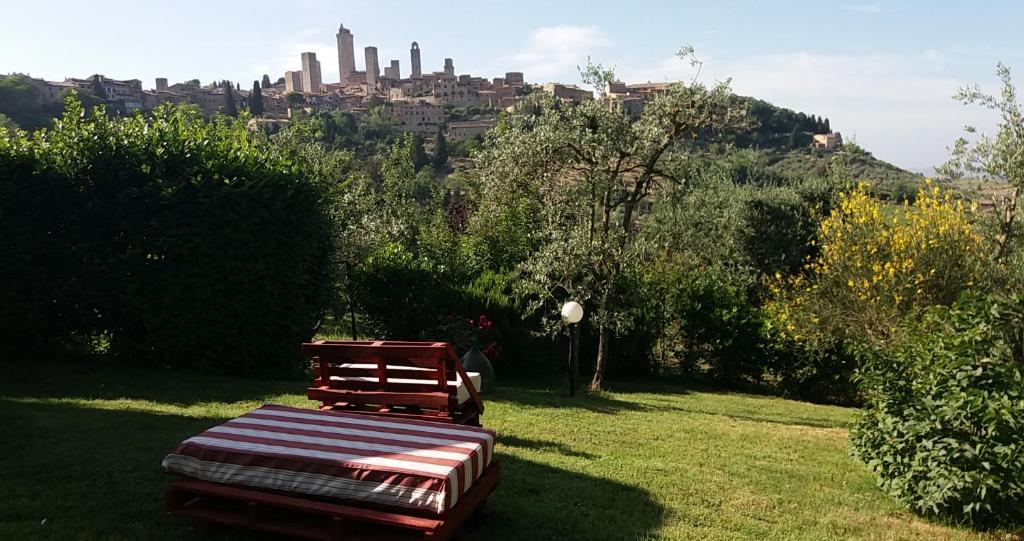 una panchina in un parco con una città sullo sfondo di Antico Casolare a San Gimignano
