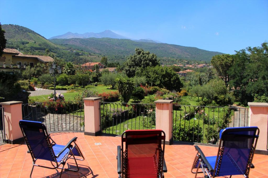 two chairs on a patio with a view of a valley at Villa Vulcano, tra l'Etna e il mare in Zafferana Etnea