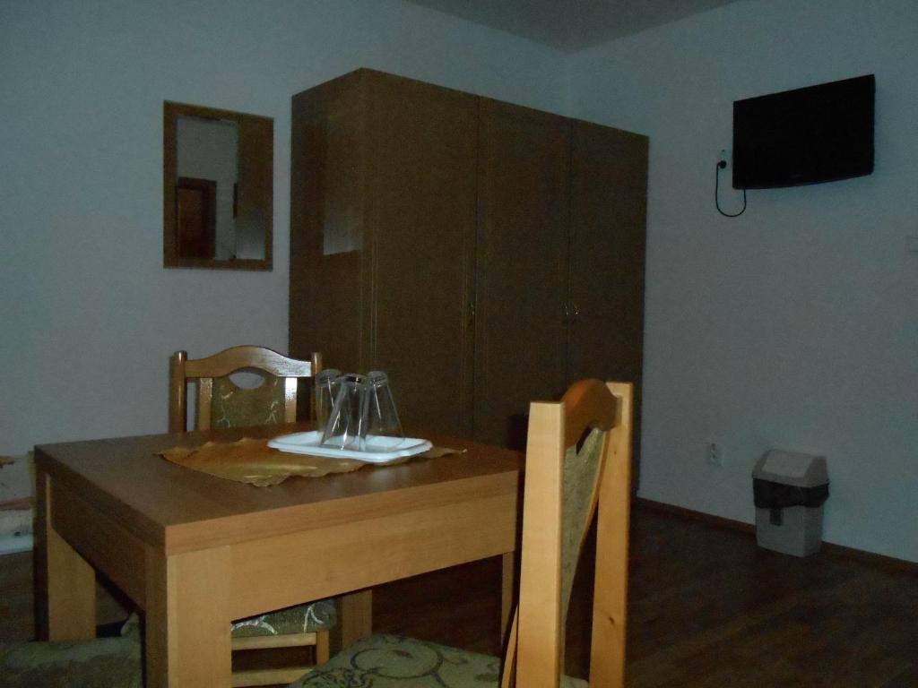 un tavolo in legno con due sedie e un piatto sopra di Penzión Pars a Žilina