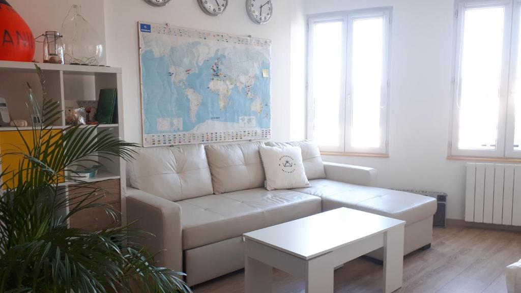 uma sala de estar com um sofá branco e uma mesa em Appartement dernier étage Hyper Centre em Granville