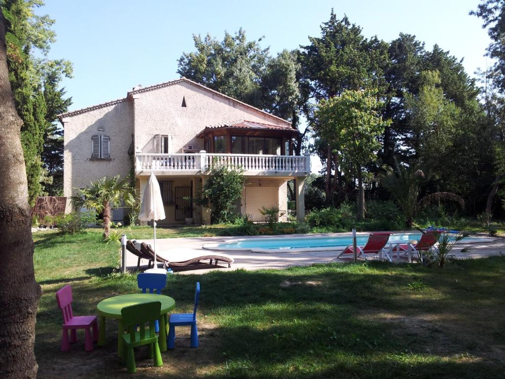 uma casa com piscina e cadeiras no quintal em La Comtadine em Avignon