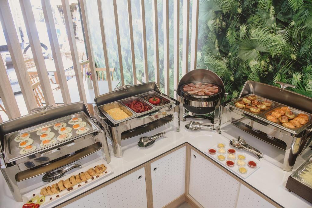 a buffet with pastries and other food on a counter at Ammos Beach Seaside Luxury Suites Hotel in Olympic Beach