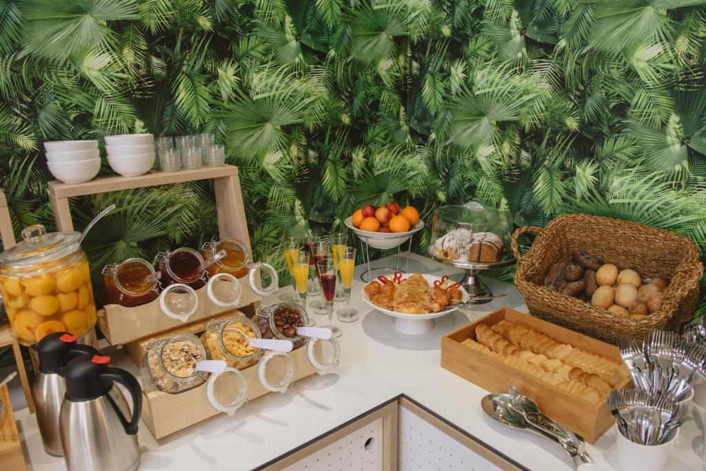 a table with a buffet of food on it at Ammos Beach Seaside Luxury Suites Hotel in Olympic Beach