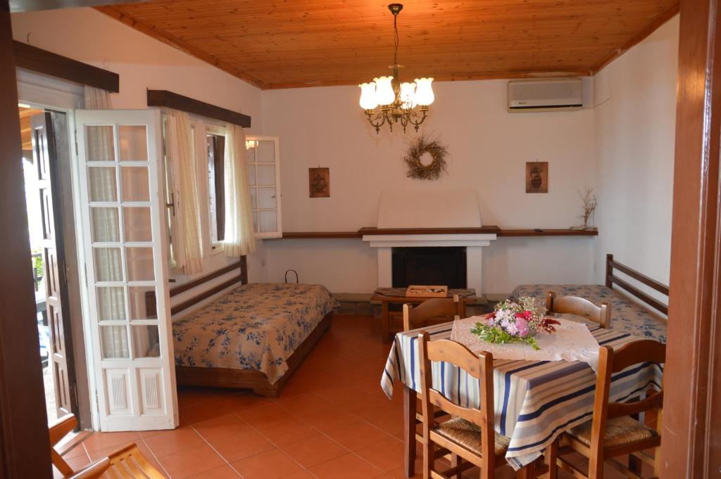 a living room with a table and a bed and a bedroom at Triantafyllia's House in Agios Ioannis Pelio