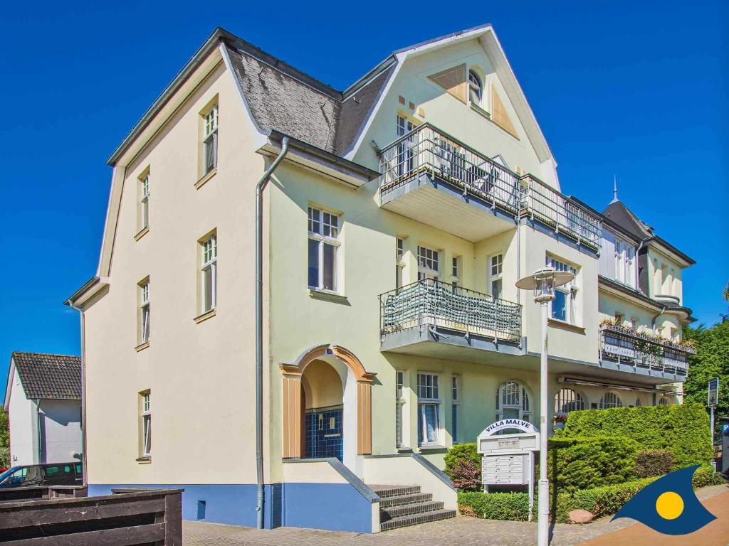ein großes weißes Gebäude mit Balkon auf einer Straße in der Unterkunft Villa Malve Wohnung 05 in Bansin